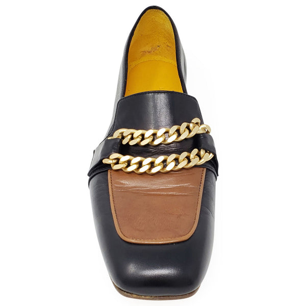 Black loafer with tan footbed and gold chain across the vamp; low heel.