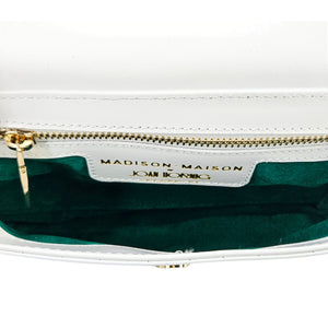 Small crossbody bag interior with green lining, gold zipper, and brand label tag