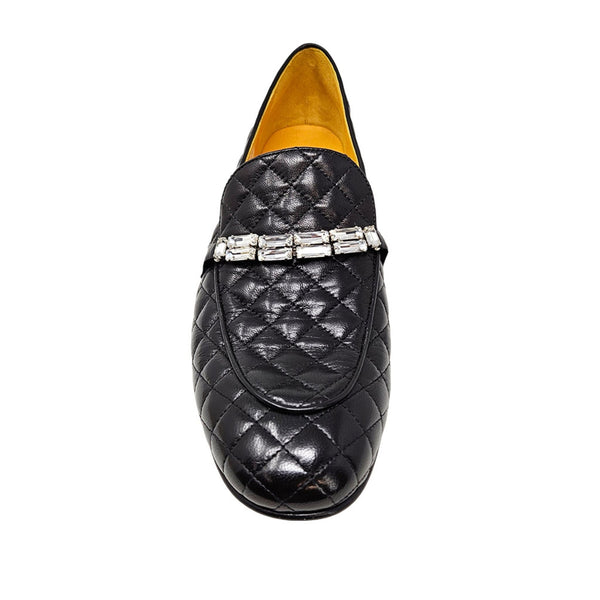 Quilted black flat loafer with diamond stitching and metallic buckle strap