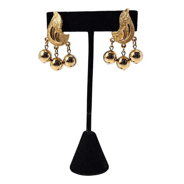 Gold clip-on chandelier earrings with textured curved fronts and three round dangling beads