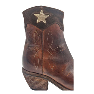 Cognac leather ankle boots with pointed toe, star applique, and stitched details