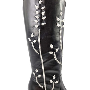 Black tall leather cowboy boot shaft with white floral embroidery close-up detail