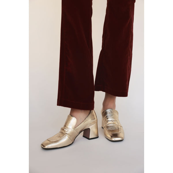 Gold leather hidden-bit loafer with mid block heel, worn with maroon pants