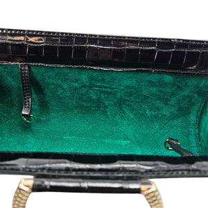 Croc-embossed clutch interior with green lining and snap-top hardware