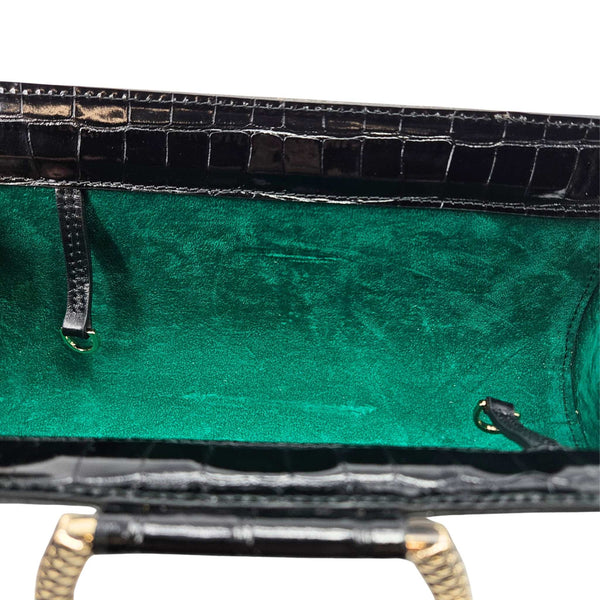 Croc-embossed clutch interior with green lining and snap-top hardware