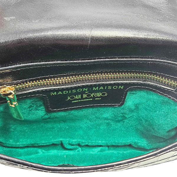 Small crossbody bag interior with green fabric lining and branding label