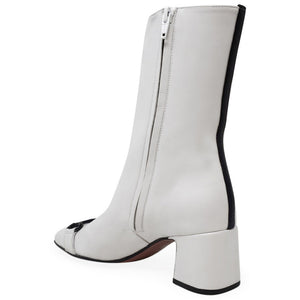 White leather mid-calf boot with side zipper, low block heel, and strap detail
