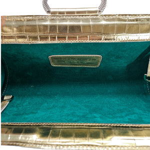Gold leather clutch open to show teal fabric lining and center label