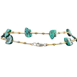 Green stone bead necklace close-up with gold-toned links and central clasp.