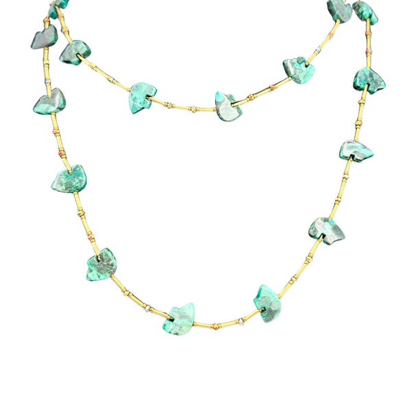 Green stone bead necklace viewed from above with gold-toned chain and drops.