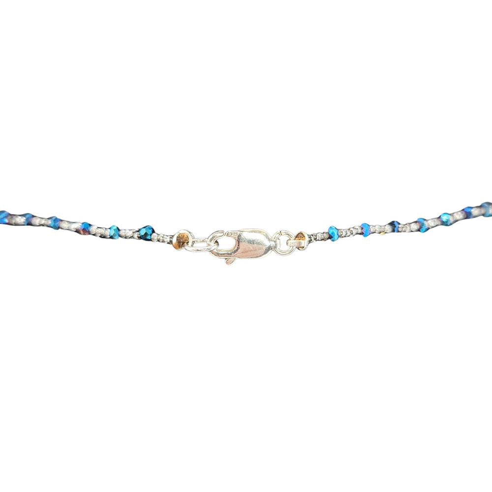 Blue beaded necklace with blue heart pendant and small clear accents