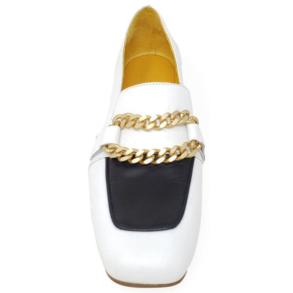 White loafer with gold curb-chain across vamp and black tongue panel, low heel