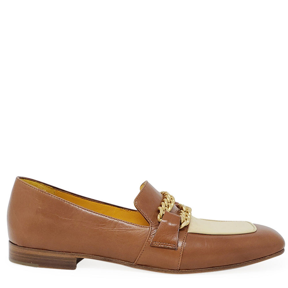 Tan flat loafer with cream panel, gold chain detail, and low wooden-look heel