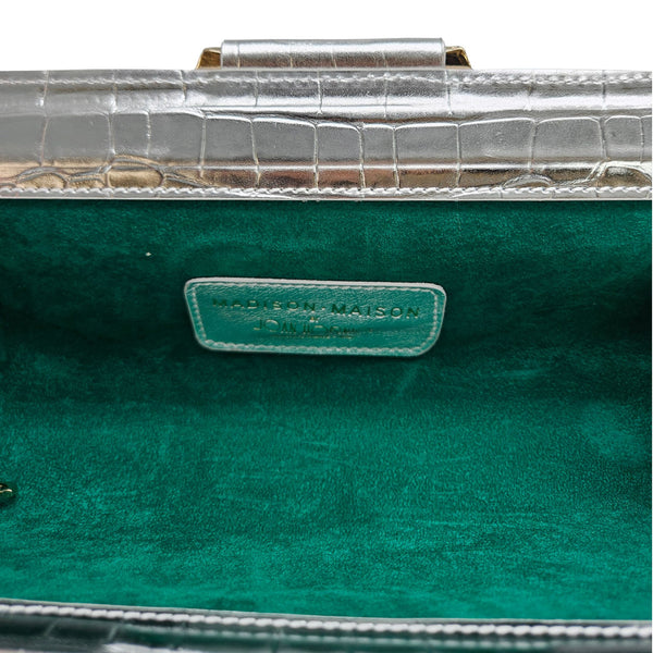Green fabric-lined clutch interior with embossed logo label