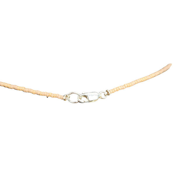 Beaded necklace strand with lobster clasp and small metal ring at center