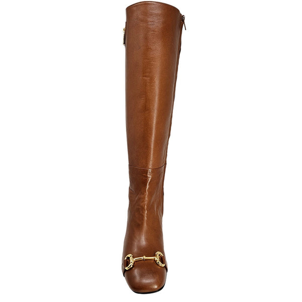Cognac tall heeled lock boot with lock pull detail and buckle hardware near toe opening