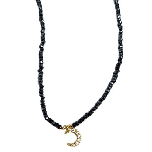 Gray beaded choker necklace with small gold crescent charm at center front
