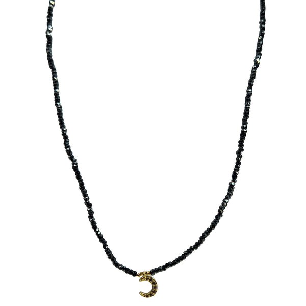 Gray beaded choker necklace in U shape with gold crescent pendant at neckline