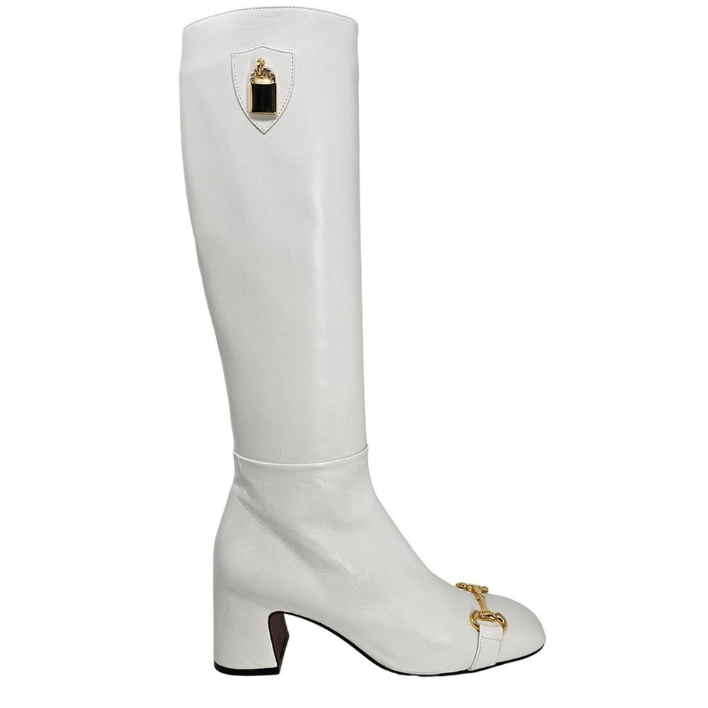 White tall boot with gold lock ornament and low block heel