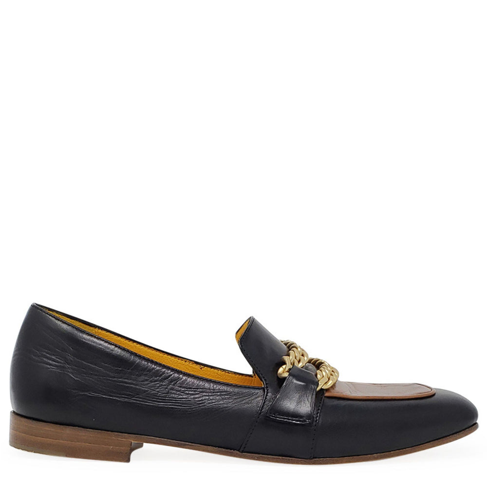Black flat loafer with tan lining, gold chain detail, and low wood-look heel.