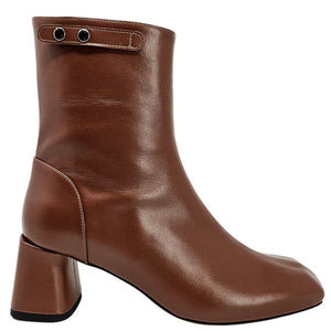 Brown leather ankle boot with chunky heel and strap with metal eyelets at top.