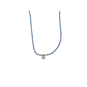 Blue beaded necklace with round crystal-and-gold charm, close view