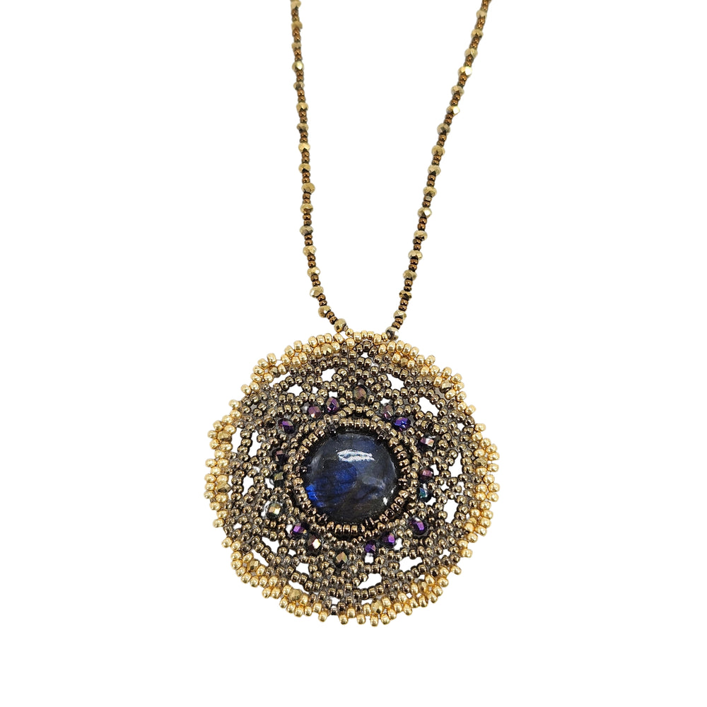 Gold-tone necklace with circular mandala pendant and dark labradorite-style center