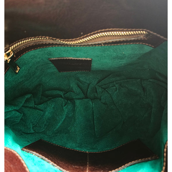 Leather shoulder bag interior with green lining, zip top, and stitched pocket