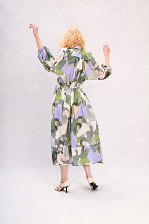 Long shirt dress with waist tie, green and lavender face print, back view