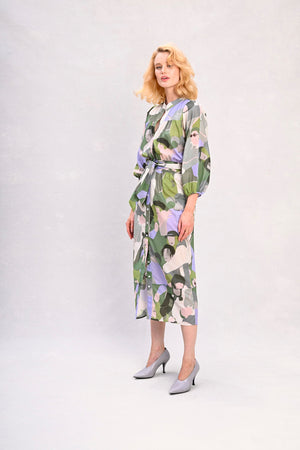 Long shirt dress with tied waist, green and lavender face print, full-body front