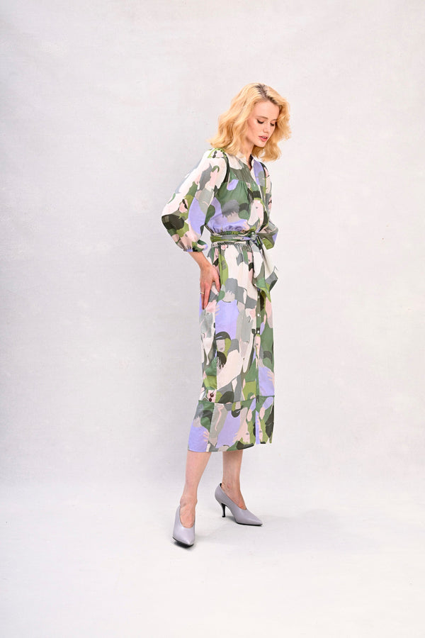 Long shirt dress with waist tie, green and lavender face print, angled front view