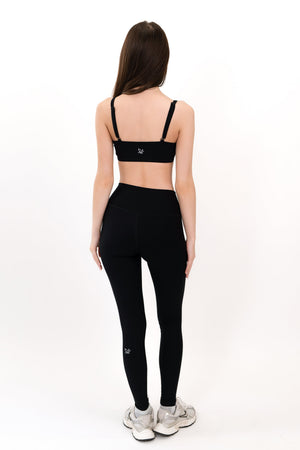 Black high-waist leggings, back view with small left-thigh logo.
