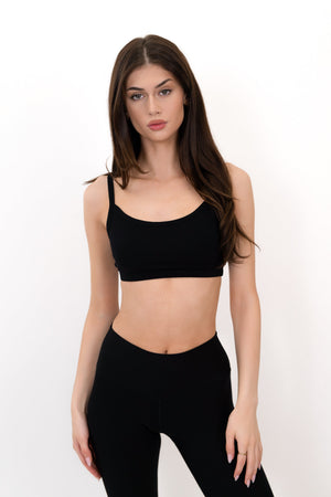 Black sports bra with thin straps and scoop neckline, front view