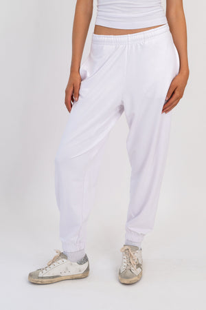 White sweatpants with gathered elastic waistband and tapered leg