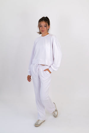 White crew neck pullover with long sleeves and drawstring waist hem.