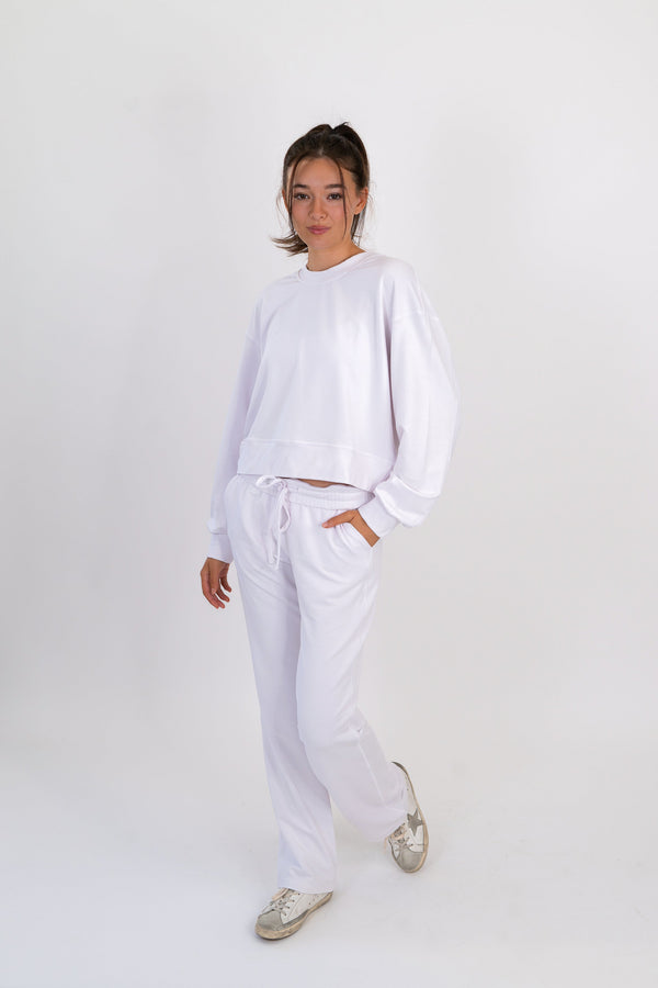 White crew neck pullover with long sleeves and drawstring waist hem.