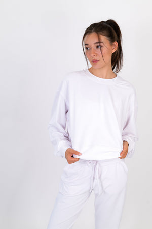 White crew neck pullover with long sleeves and tied drawstring waist hem.