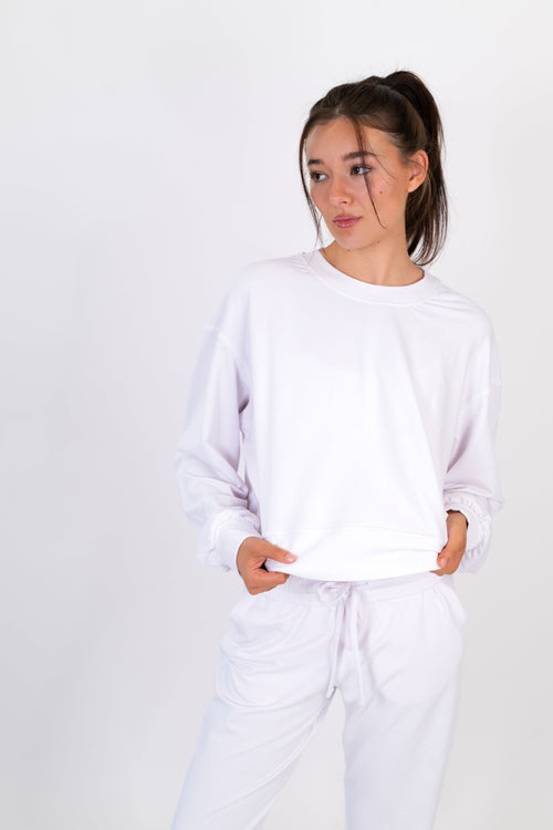 White crew neck pullover with long sleeves and tied drawstring waist hem.