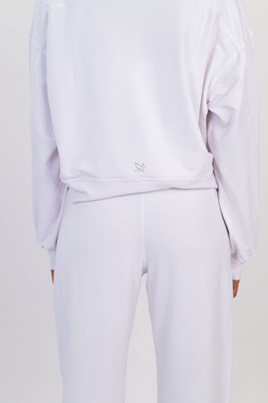 White crew neck pullover close-up, back view, small logo at hem and drawstring waist.