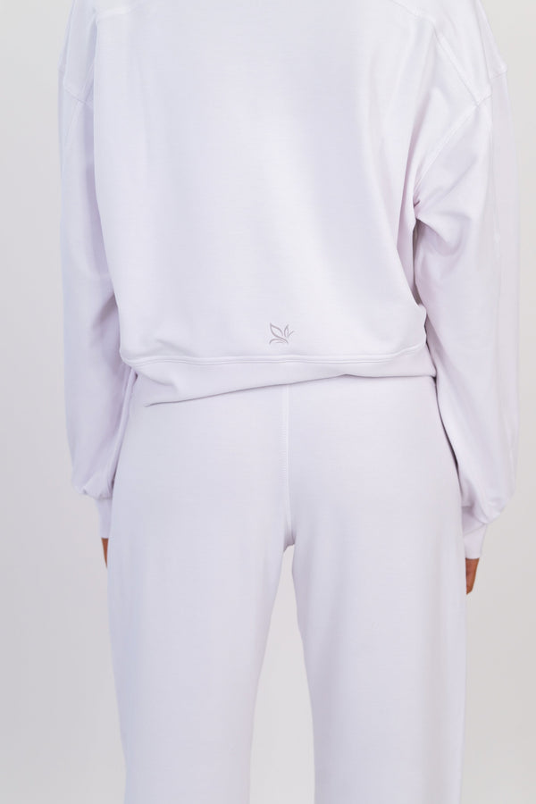White crew neck pullover close-up, back view, small logo at hem and drawstring waist.