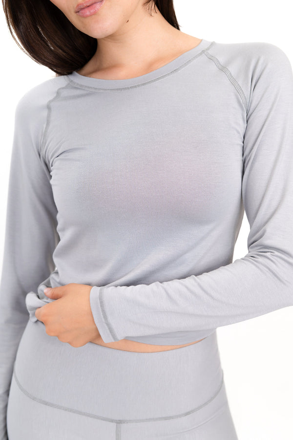 Gray long-sleeve crewneck shirt close-up with neckline trim and smooth knit finish.