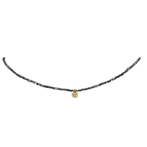 Grey beaded necklace with small gold star coin charm centerpiece