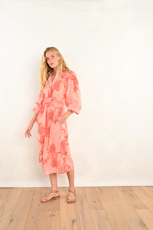 Coral pink floral midi dress with V-neck, long billowy sleeves, and fitted waist.
