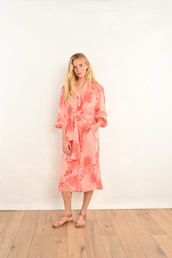 Coral pink floral midi dress with V-neck and elastic waist; long flowing sleeves.