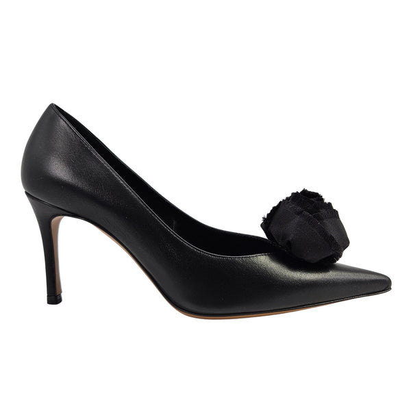 Black leather heel pump with fabric flower detail at the toe and slim high heel.