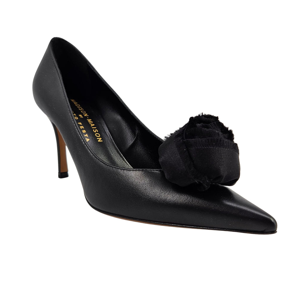 Black leather heel pump with fabric flower detail at the toe and slim high heel.