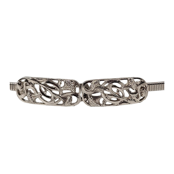Silver stretch belt buckle with detailed scrollwork and textured side ends