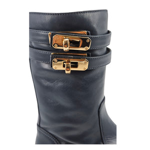 Navy shearling-lined platform boots close-up of double gold buckle straps on shaft