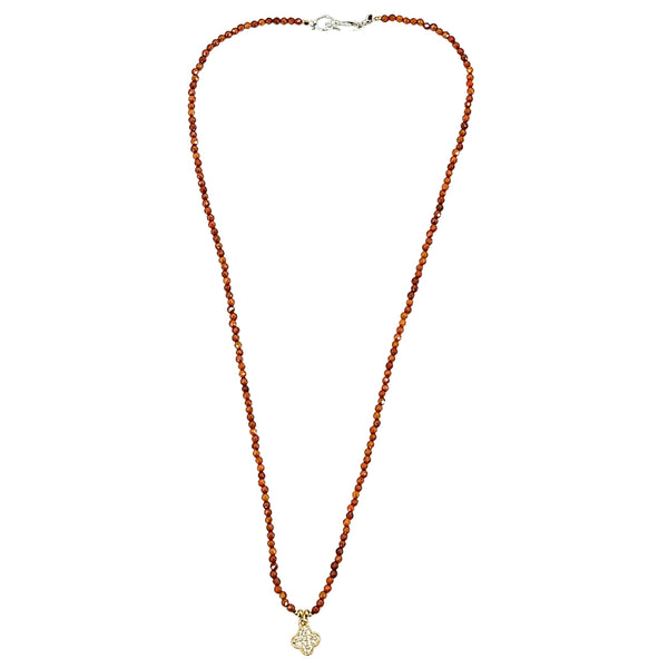 Long orange faceted bead necklace with clover charm pendant and silver clasp at back