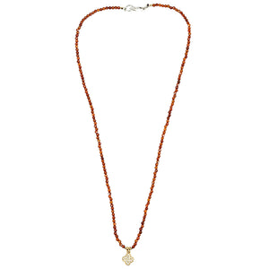 Orange beaded necklace with faceted beads and clover charm at center, silver clasp